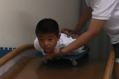 感统训练项目：俯卧在滑板车上滑下大滑梯